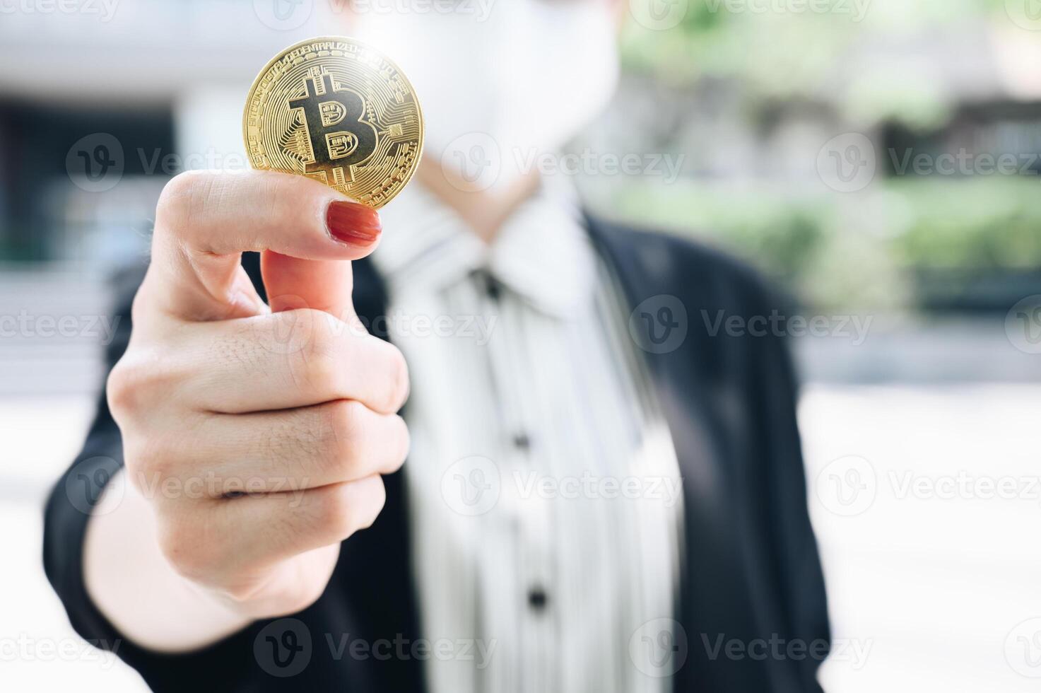 Businesswoman holding a Bitcoin token. Bitcoin is one of the popular cryptocurrency, a virtual currency or a digital currency. photo
