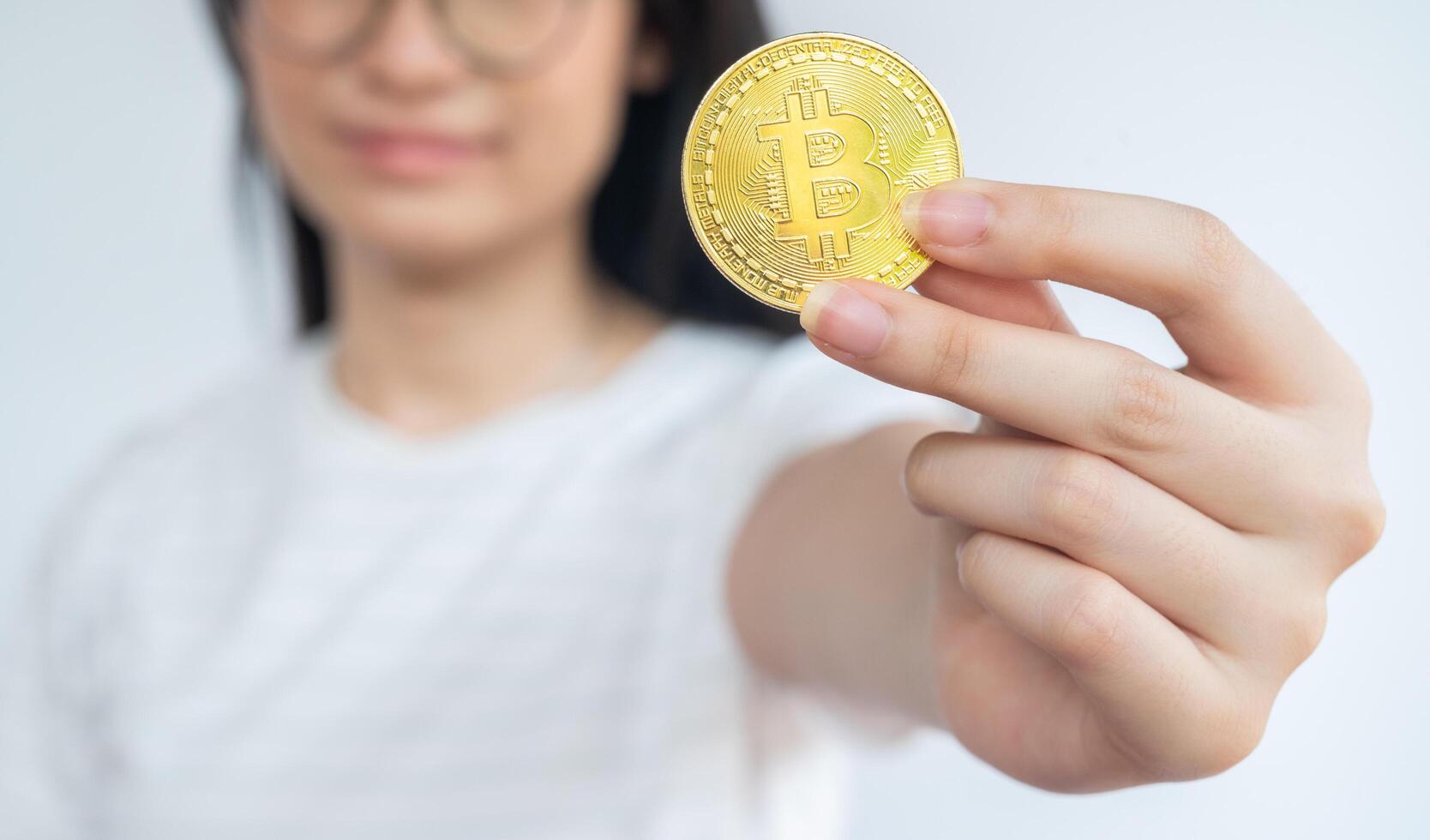 Woman holding a Bitcoin token. photo
