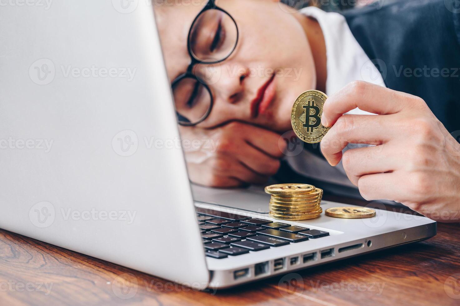 Worried businesswoman lying on desk and looking to Bitcoin token. photo