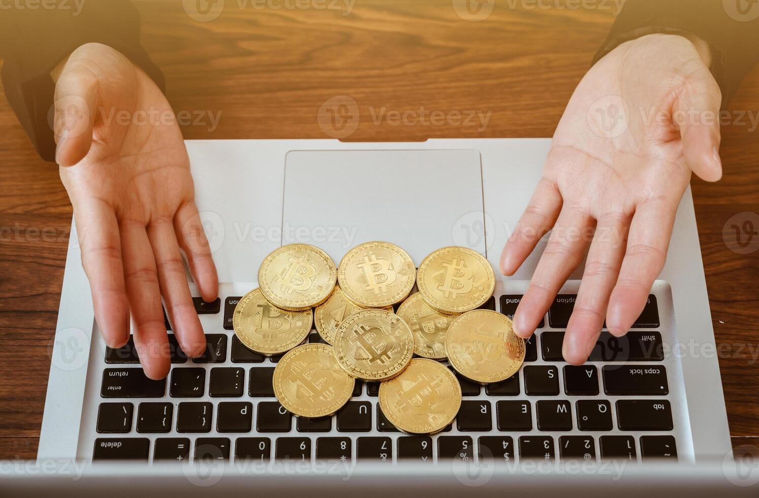 Close up of human hand put some pieces of golden Bitcoin token on laptop. Bitcoin is one of the popular cryptocurrency, a virtual currency or a digital currency. photo