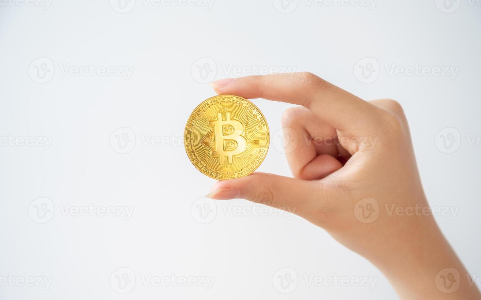 Someone hand holding a golden Bitcoin token isolated on white background. Bitcoin is one of the popular cryptocurrency, a virtual currency or a digital currency. photo