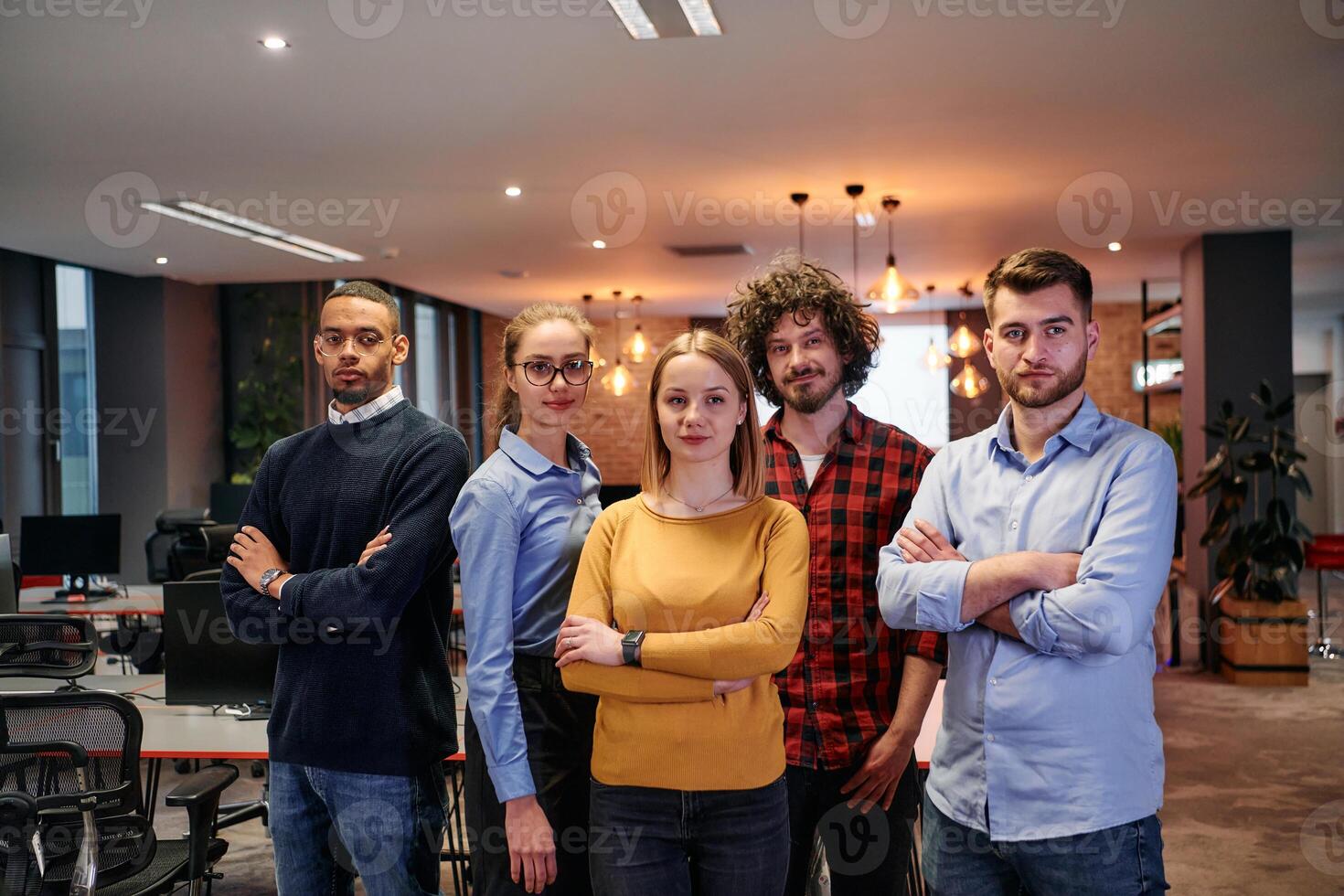 Portrait of successful creative business team looking at camera and smiling. Diverse business people standing together at startup. Selective focus photo