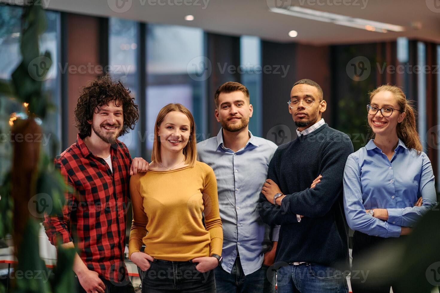 Portrait of successful creative business team looking at camera and smiling. Diverse business people standing together at startup. Selective focus photo