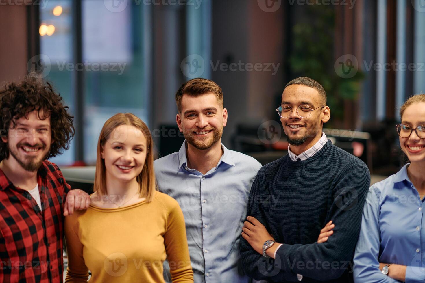 Portrait of successful creative business team looking at camera and smiling. Diverse business people standing together at startup. Selective focus photo