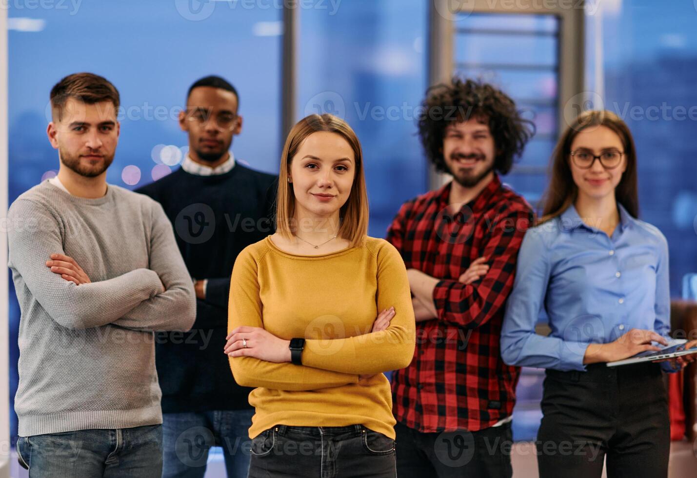 Portrait of successful creative business team looking at camera and smiling. Diverse business people standing together at startup. Selective focus photo
