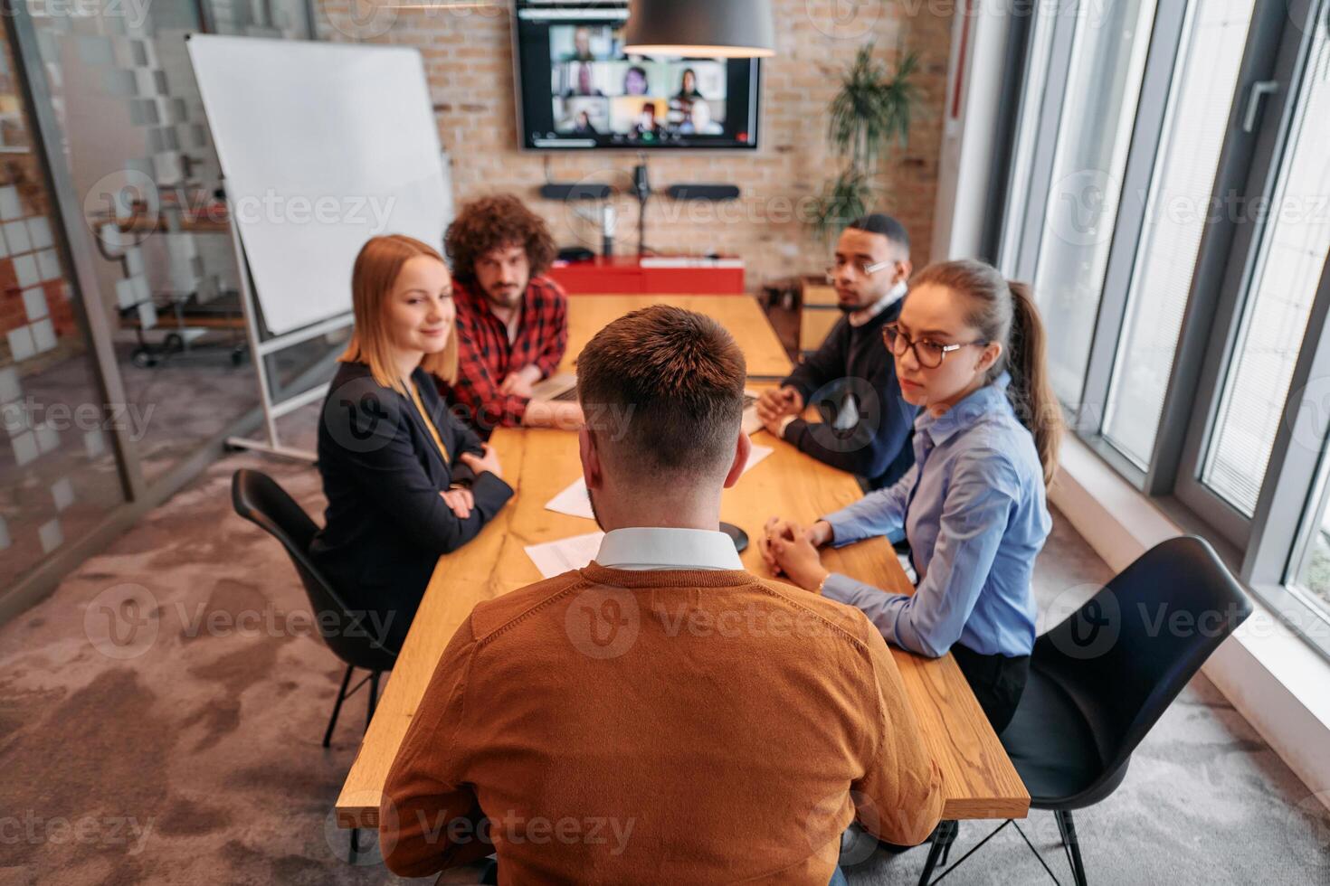 Top view of a modern startup office, a diverse team of business professionals engage in discussions on various projects and develop new business strategies, epitomizing creativity and innovation in photo