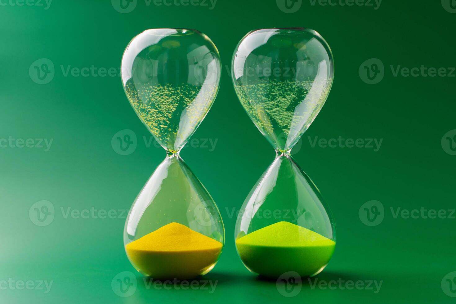 Hourglass standing still on green background, time concept and definition of oscillating period. photo