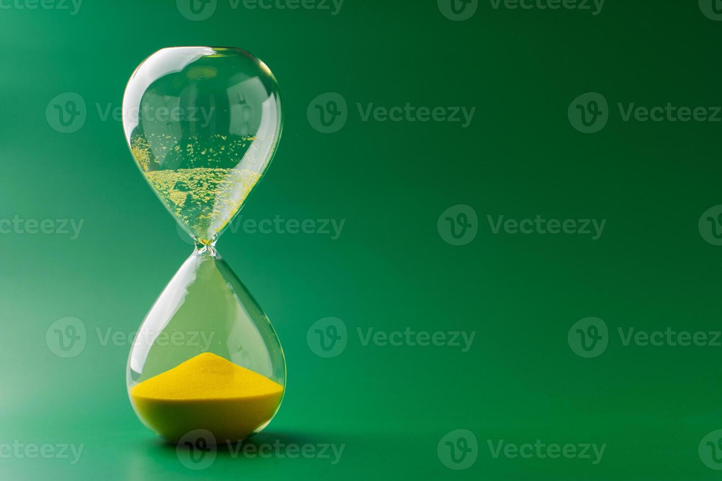Hourglass standing still, working with time limit and limits, photo in studio on green background