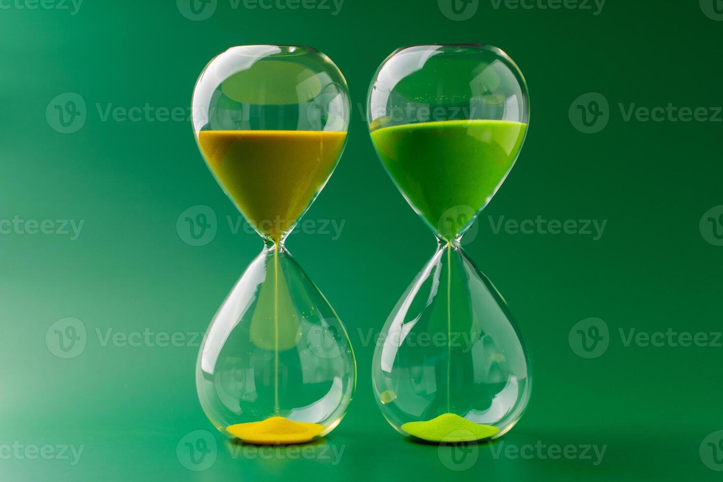 Hourglass standing still, working with time limit and limits, photo in studio on green background