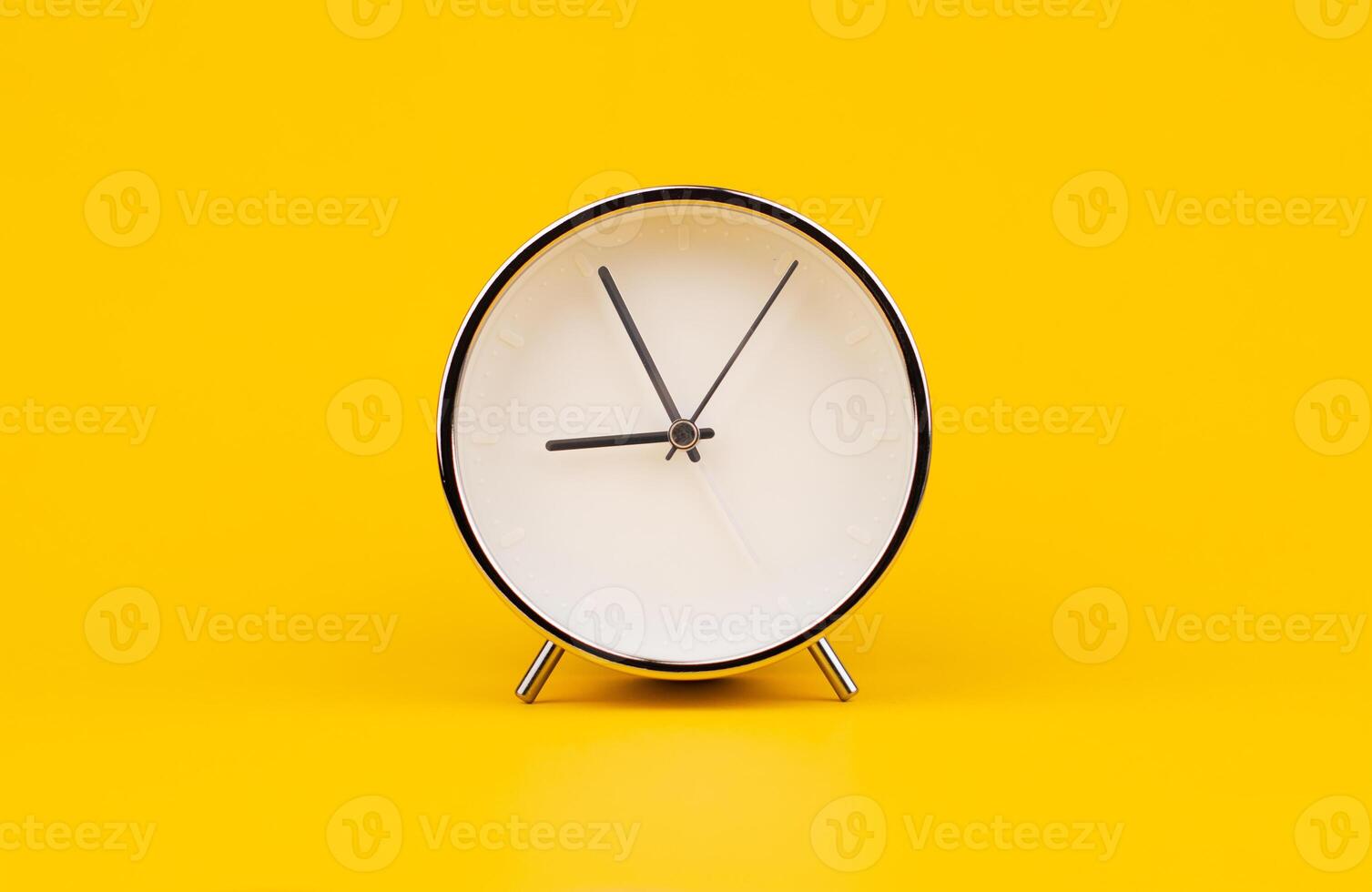 Alarm clock. Stationary photo in studio on yellow background, time concept.