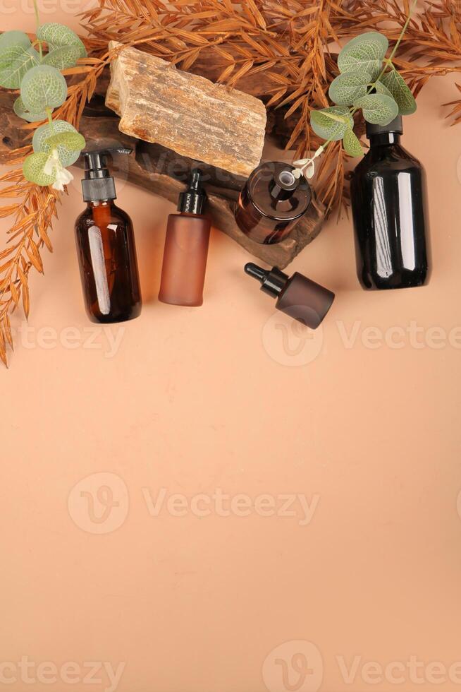 Elegant Amber Glass Skincare Bottles on Rustic Background with Foliage photo