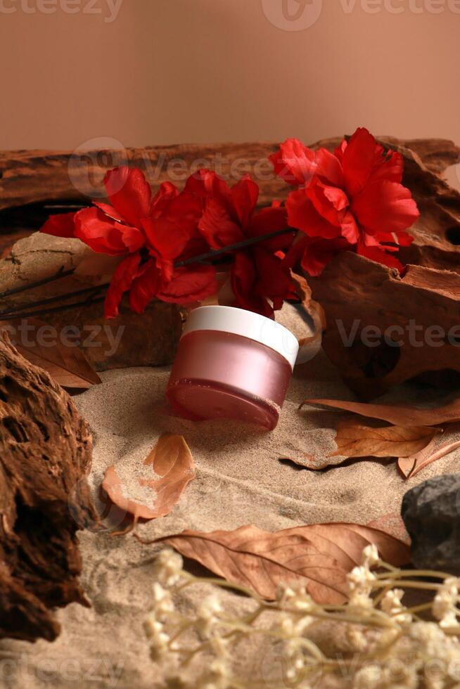 Elegant Skincare Jar with Red Flowers on Natural Sand Background photo