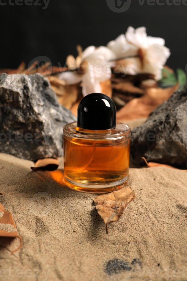 Elegant Amber Glass Bottle on Natural Sand Background photo