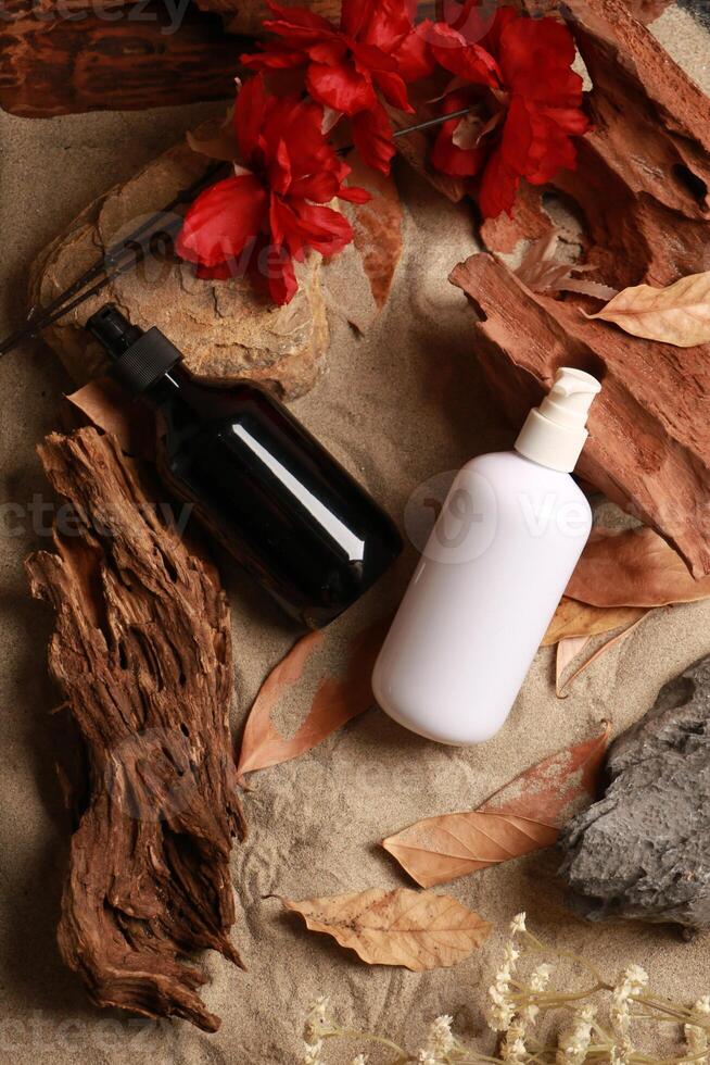 Elegant Skincare Bottles with Natural Elements and Red Flowers photo