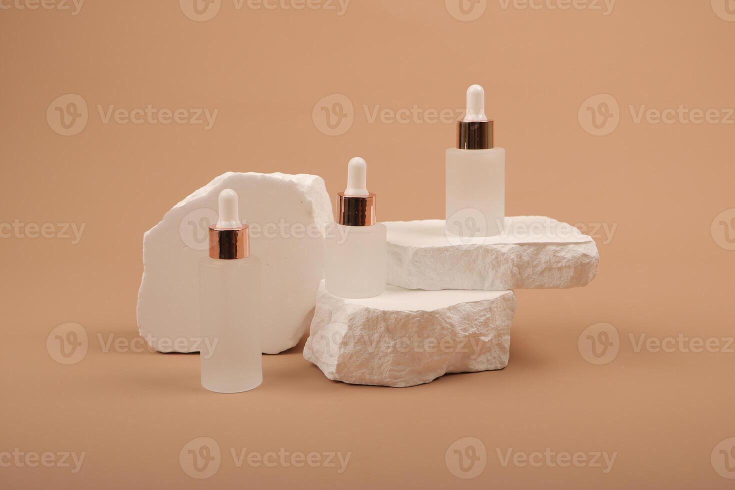 Elegant Frosted Dropper Bottles with Rose Gold Caps on White Stone Display photo