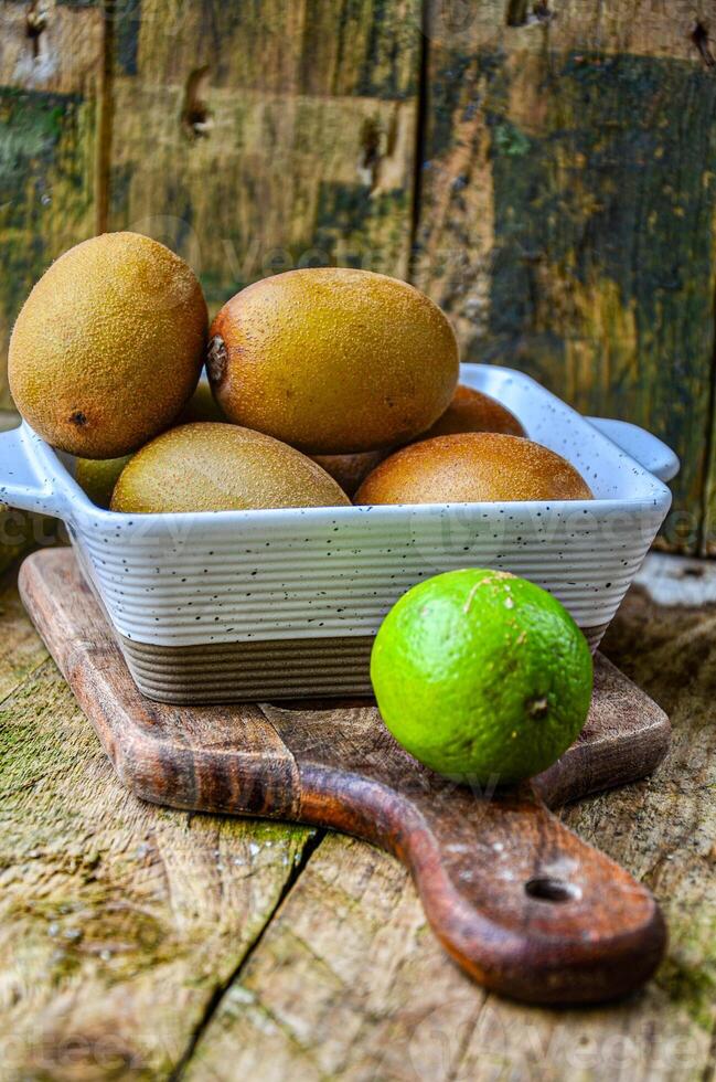 kiwi in a white ceramic bowl on a wooden background on a kitchen board photo