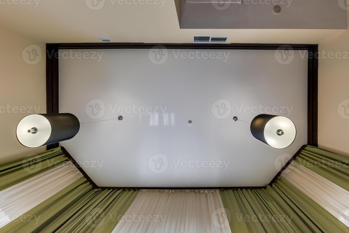 suspended ceiling with halogen spots lamps and drywall construction in empty room in apartment or house. Stretch ceiling white and complex shape. photo