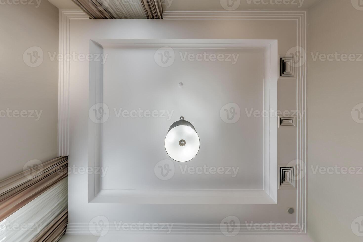 suspended ceiling with halogen spots lamps and drywall construction in empty room in apartment or house. Stretch ceiling white and complex shape. photo