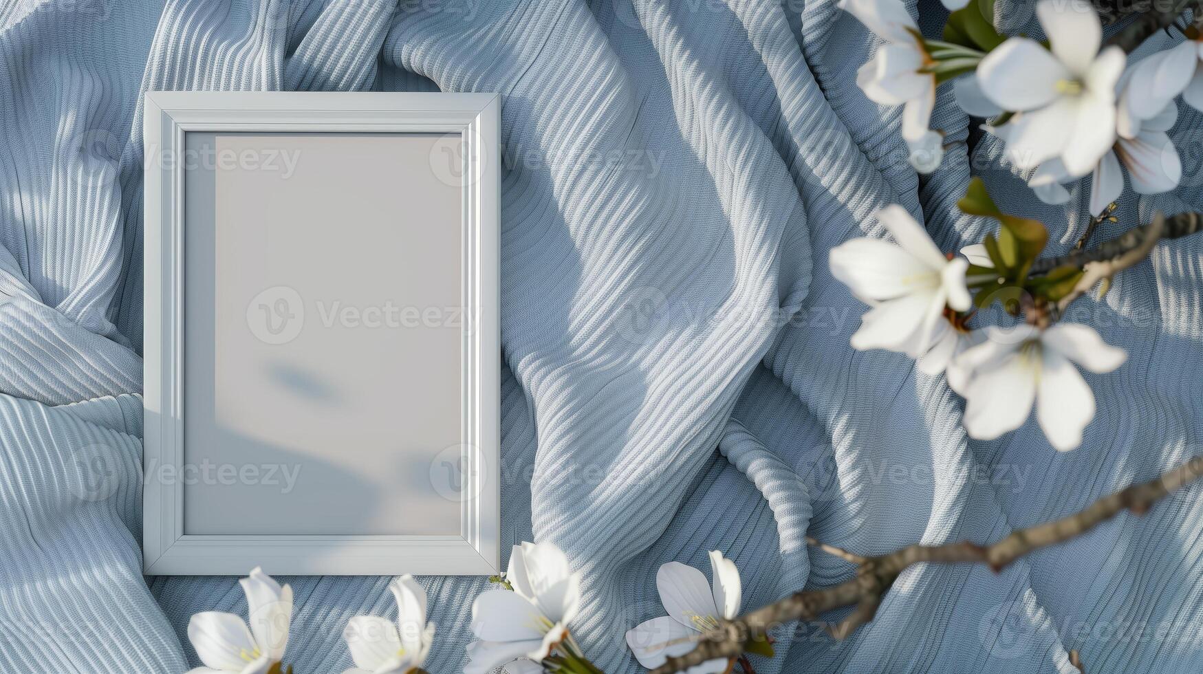 A white frame mockup, against a blue blanket with white flowers. photo