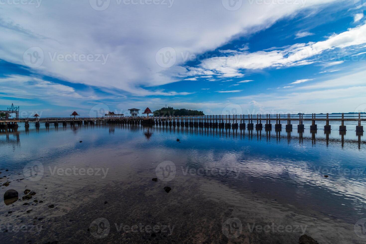 Beach landscape with jetty and reflection of sky photo