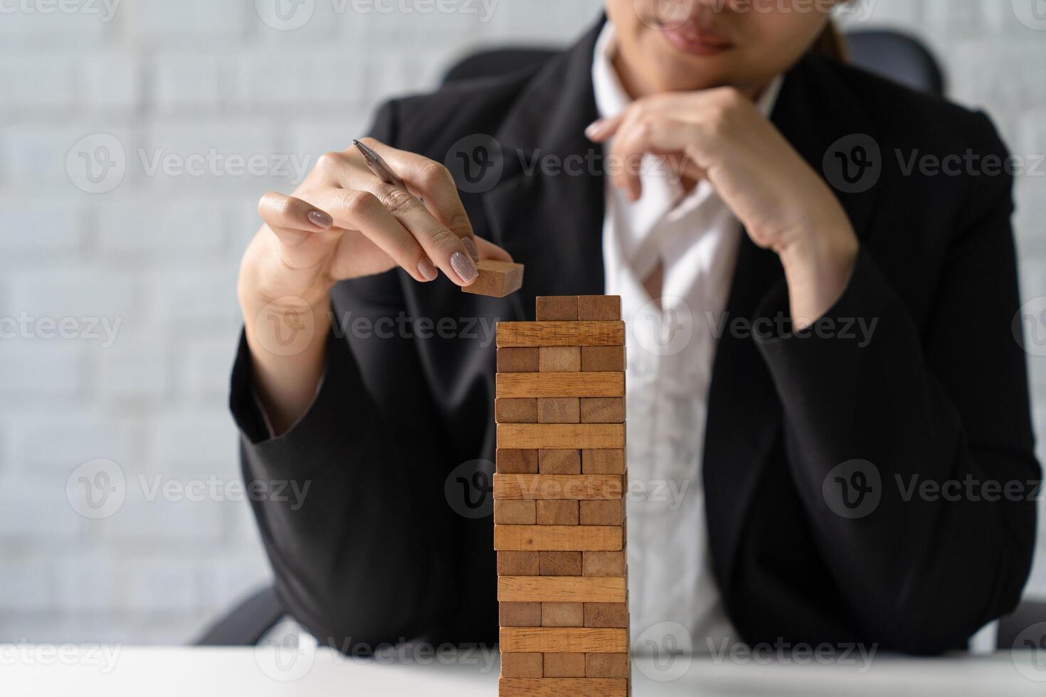 Businessman placing wooden block on a tower. Problem solution, planning, risk and strategy in business photo