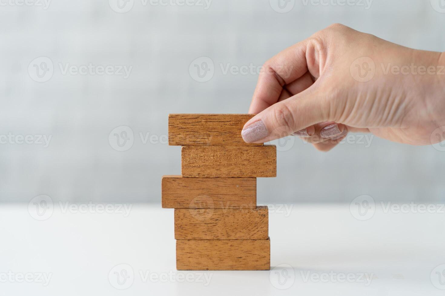 Young businesswoman places wooden blocks on white table for risk strategy plan. business concept. photo