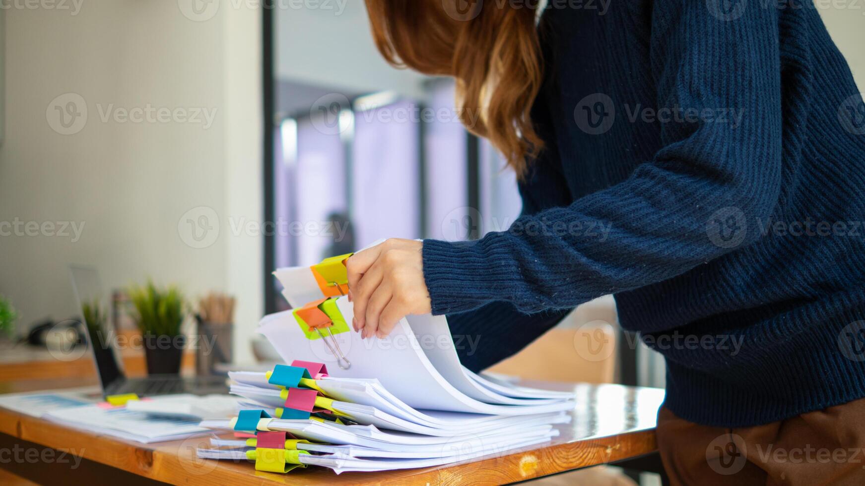 pile of documents sat on desk in office was pile of documents that had been prepared to be presented at meeting as summary of annual operations. Documents prepared for storage and piled on the desk. photo