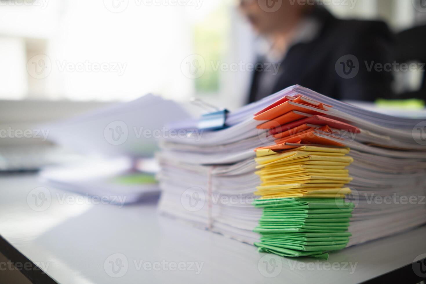 pile of documents sat on desk in office was pile of documents that had been prepared to be presented at meeting as summary of annual operations. Documents prepared for storage and piled on the desk. photo