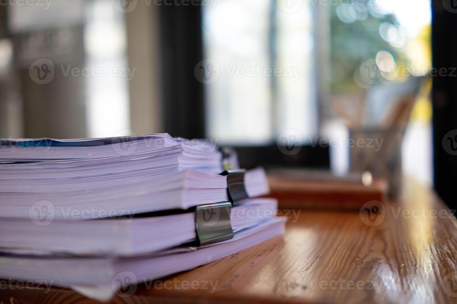 pile of documents sat on desk in office was pile of documents that had been prepared to be presented at meeting as summary of annual operations. Documents prepared for storage and piled on the desk. photo