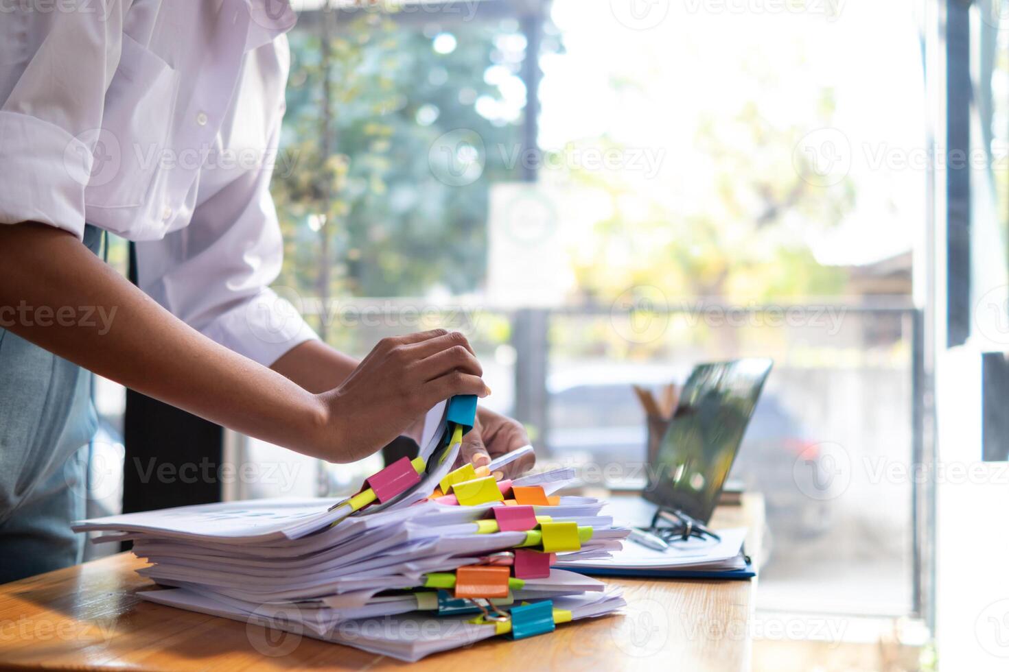 A pile of documents that the secretary has prepared for meetings of the company board of directors and investors. Many documents were arranged and prepared in piles on the desk in the secretary office photo