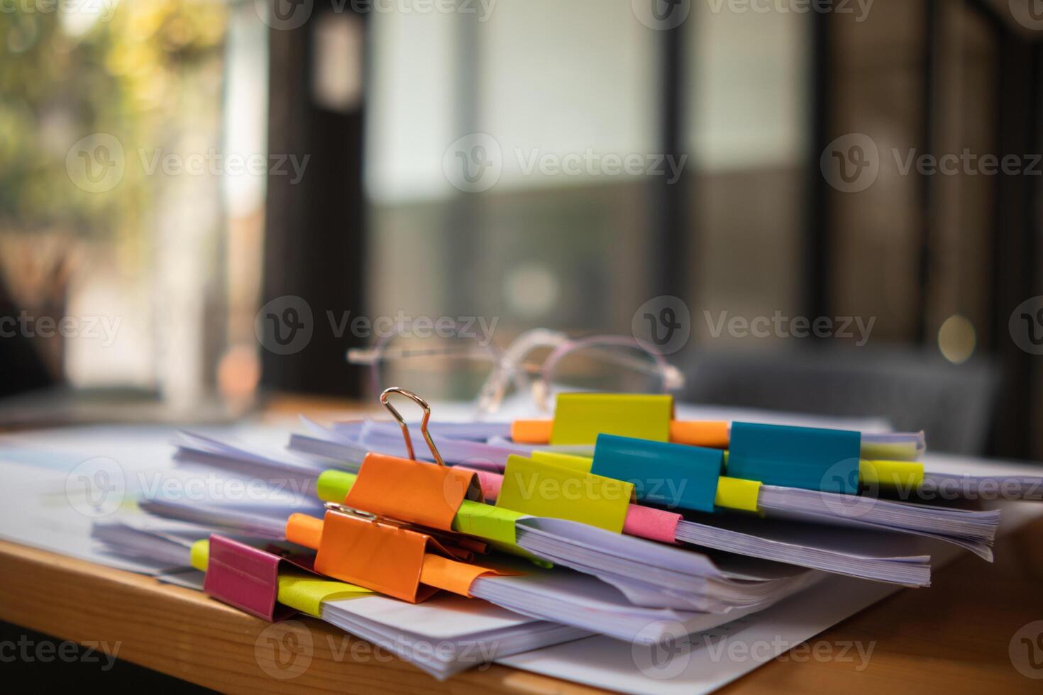 pile of documents sat on desk in office was pile of documents that had been prepared to be presented at meeting as summary of annual operations. Documents prepared for storage and piled on the desk. photo