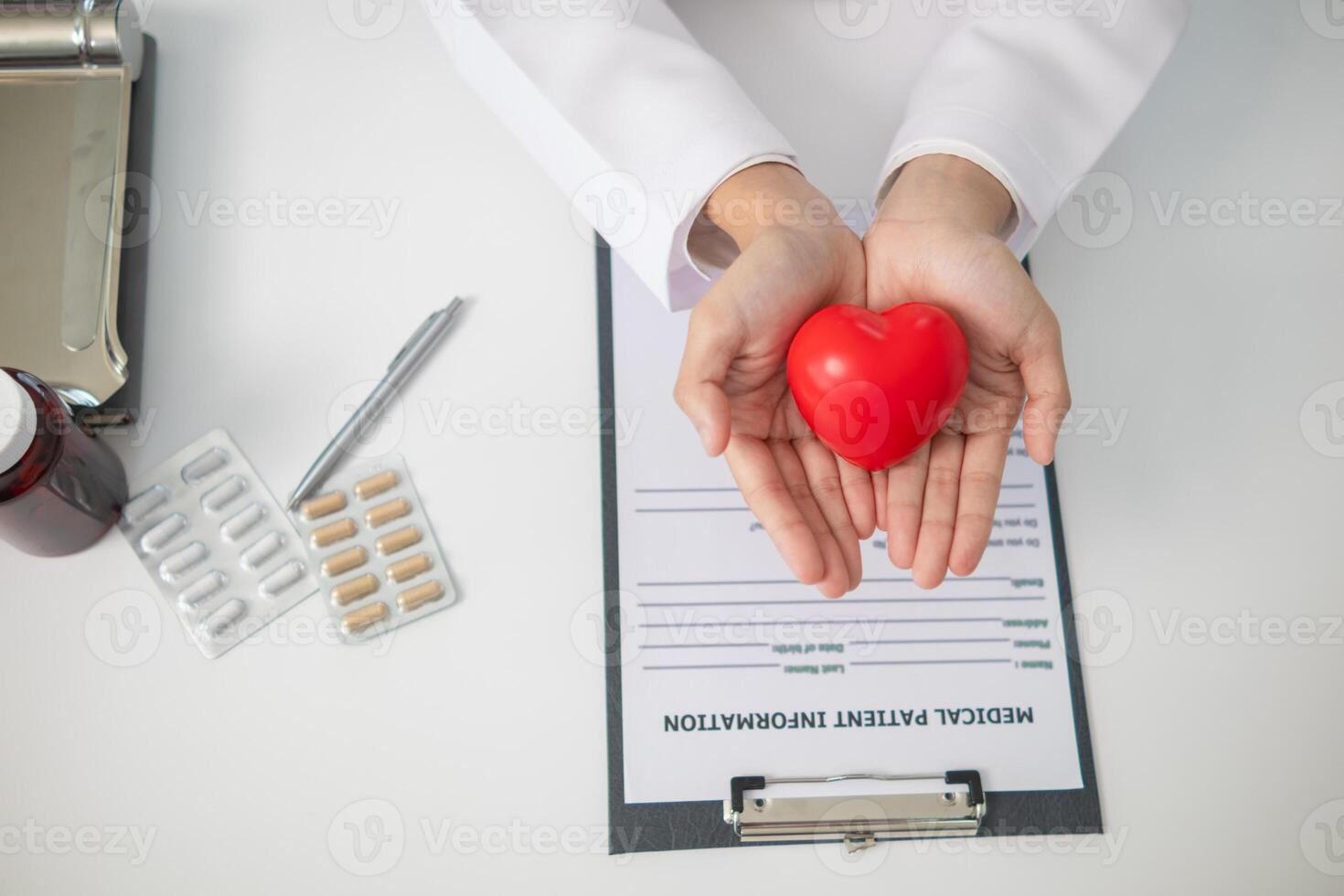 The red heart symbol in the doctor's hand is a symbol of the campaign to care for the health of heart disease patients and encourage people at risk of heart disease to come for regular check-ups. photo