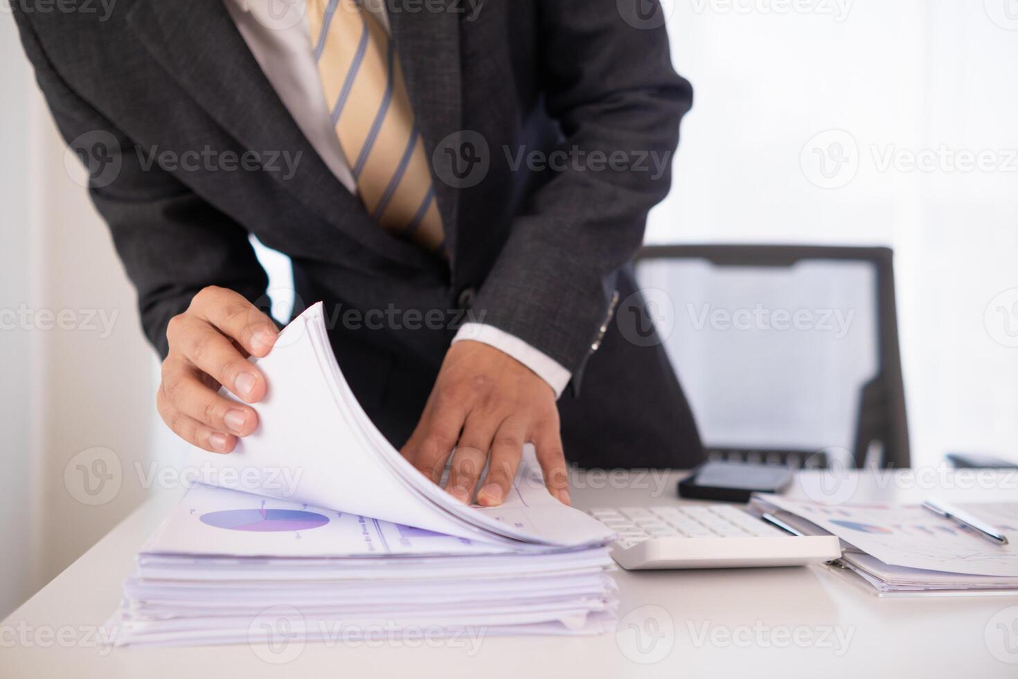 A pile of documents that the secretary has prepared for meetings of the company board of directors and investors. Many documents were arranged and prepared in piles on the desk in the secretary office photo