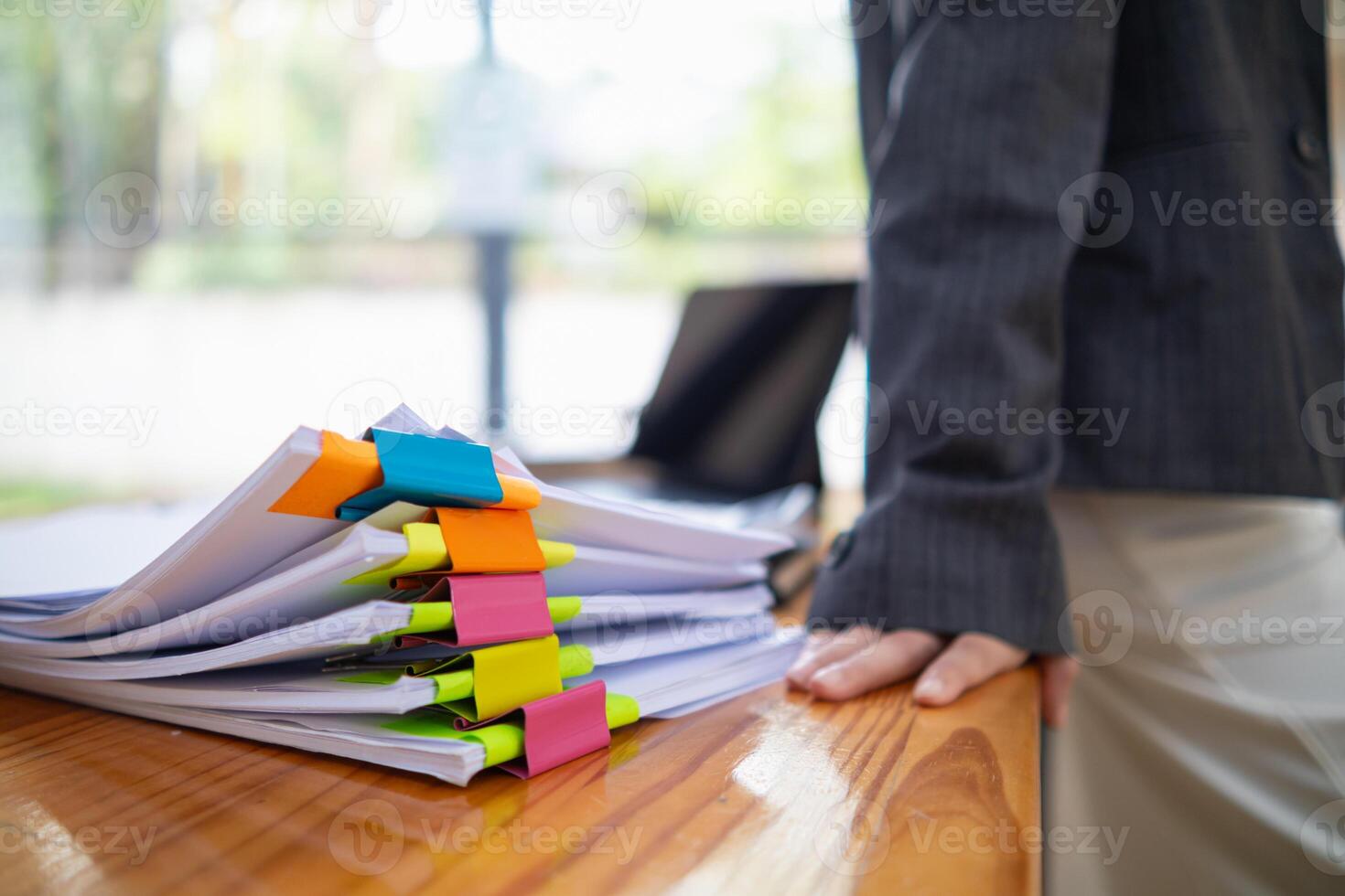 pile of documents sat on desk in office was pile of documents that had been prepared to be presented at meeting as summary of annual operations. Documents prepared for storage and piled on the desk. photo