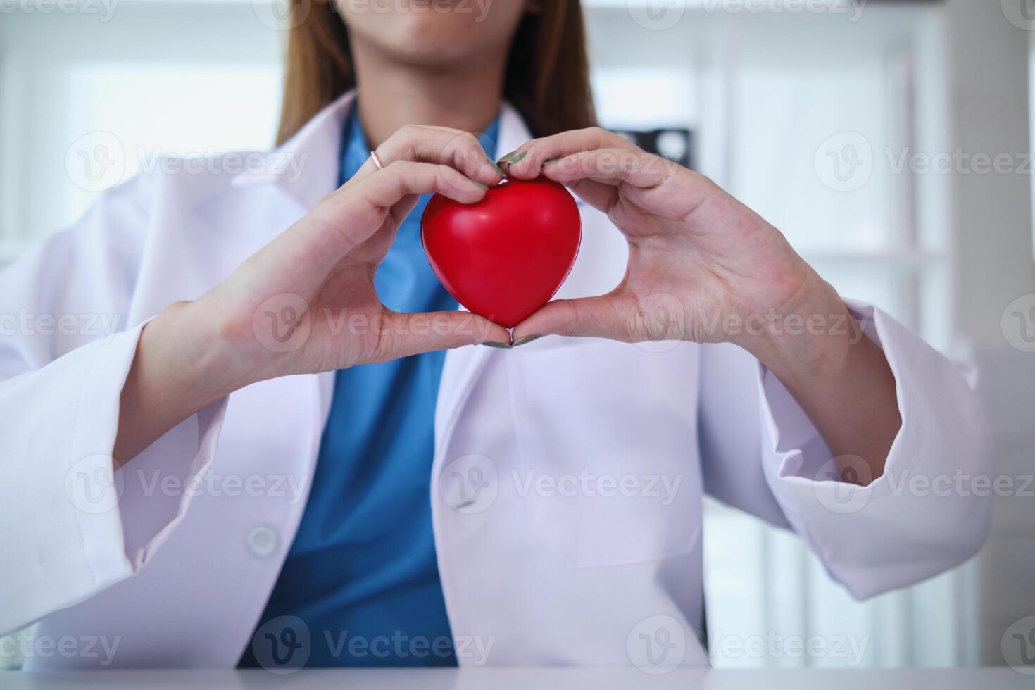 The red heart symbol in the doctor's hand is a symbol of the campaign to care for the health of heart disease patients and encourage people at risk of heart disease to come for regular check-ups. photo
