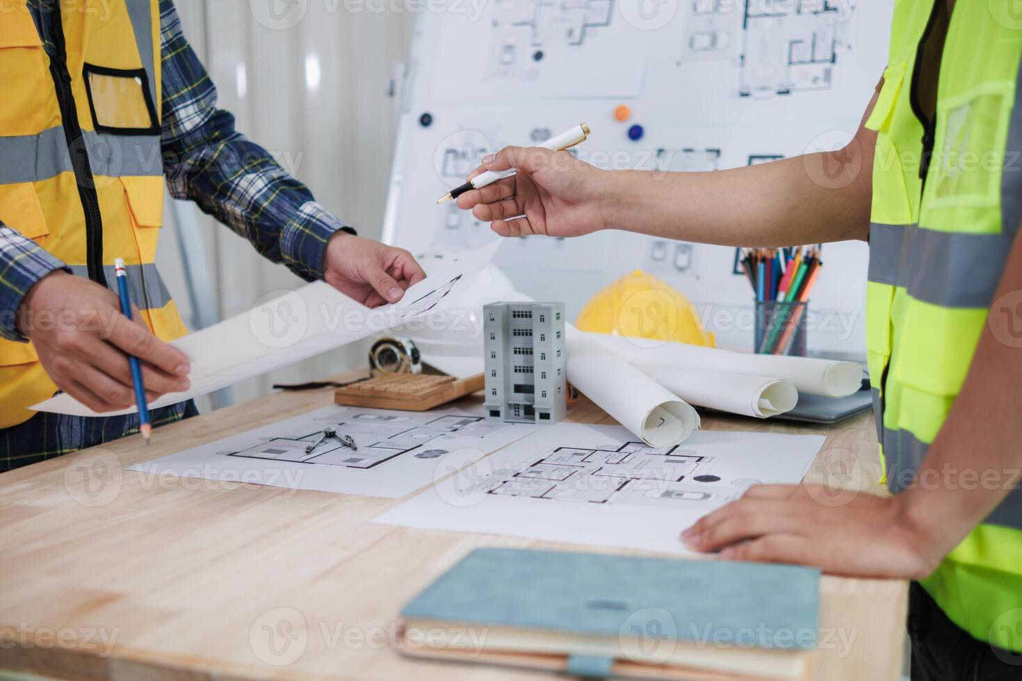 engineering is currently discussing structural design issues with architects to review plans to suit construction and stability of building. concept joint consultation between engineers and architects photo