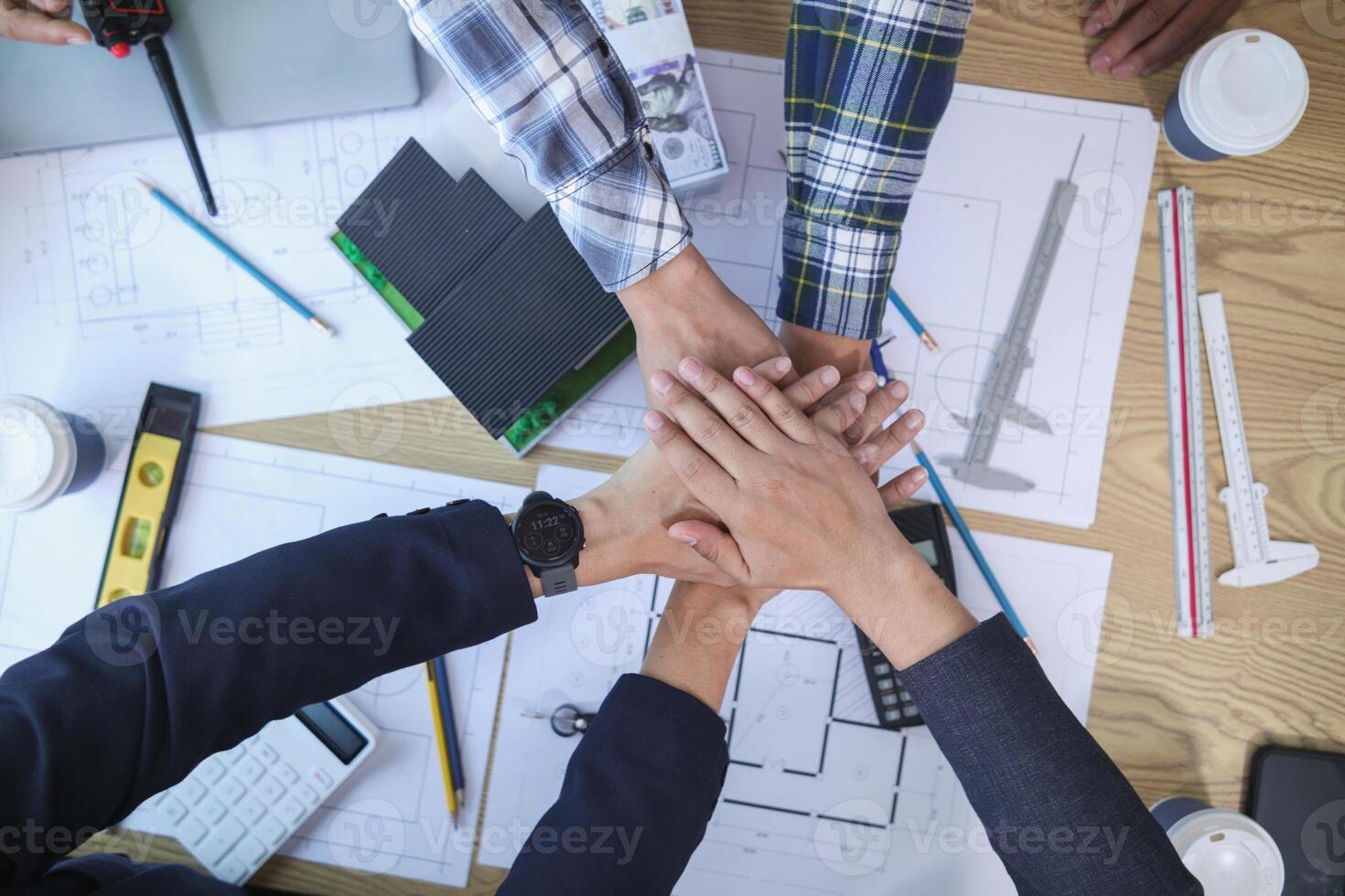 group of businessmen and investors join hands to symbolize cooperation in investing in real estate business together. concept of touching hands touching hands together to show cooperation and promise. photo