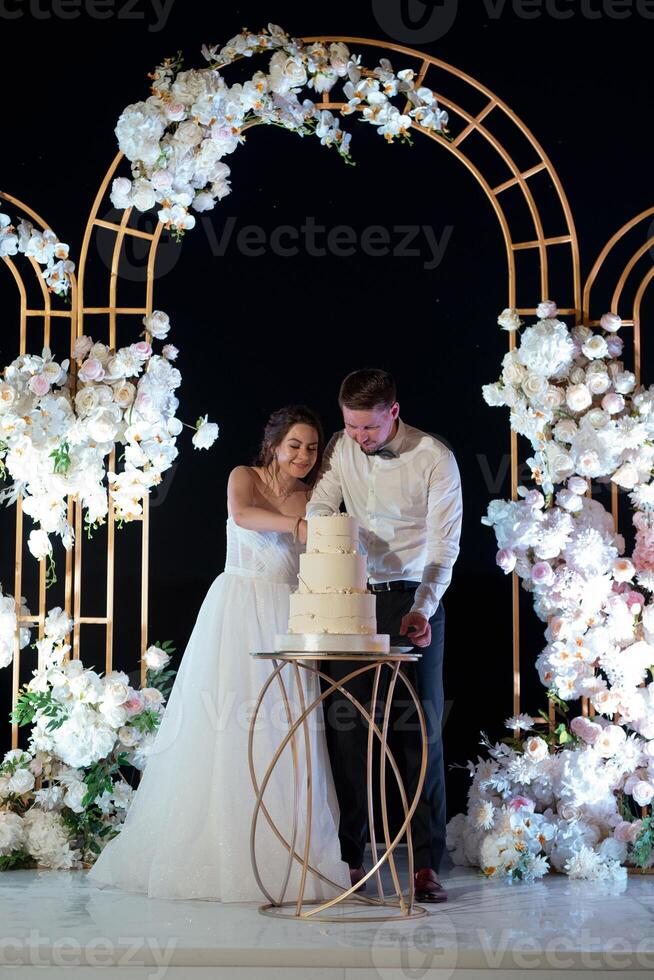newlyweds happily cut and taste the wedding cak photo