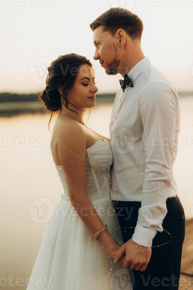 bride and groom against the backdrop of a yellow sunset photo