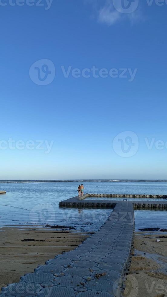 Couple Walking on Floating Dock at Beach photo