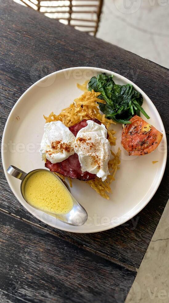 there is a plate of food with eggs, spinach and tomatoes. photo