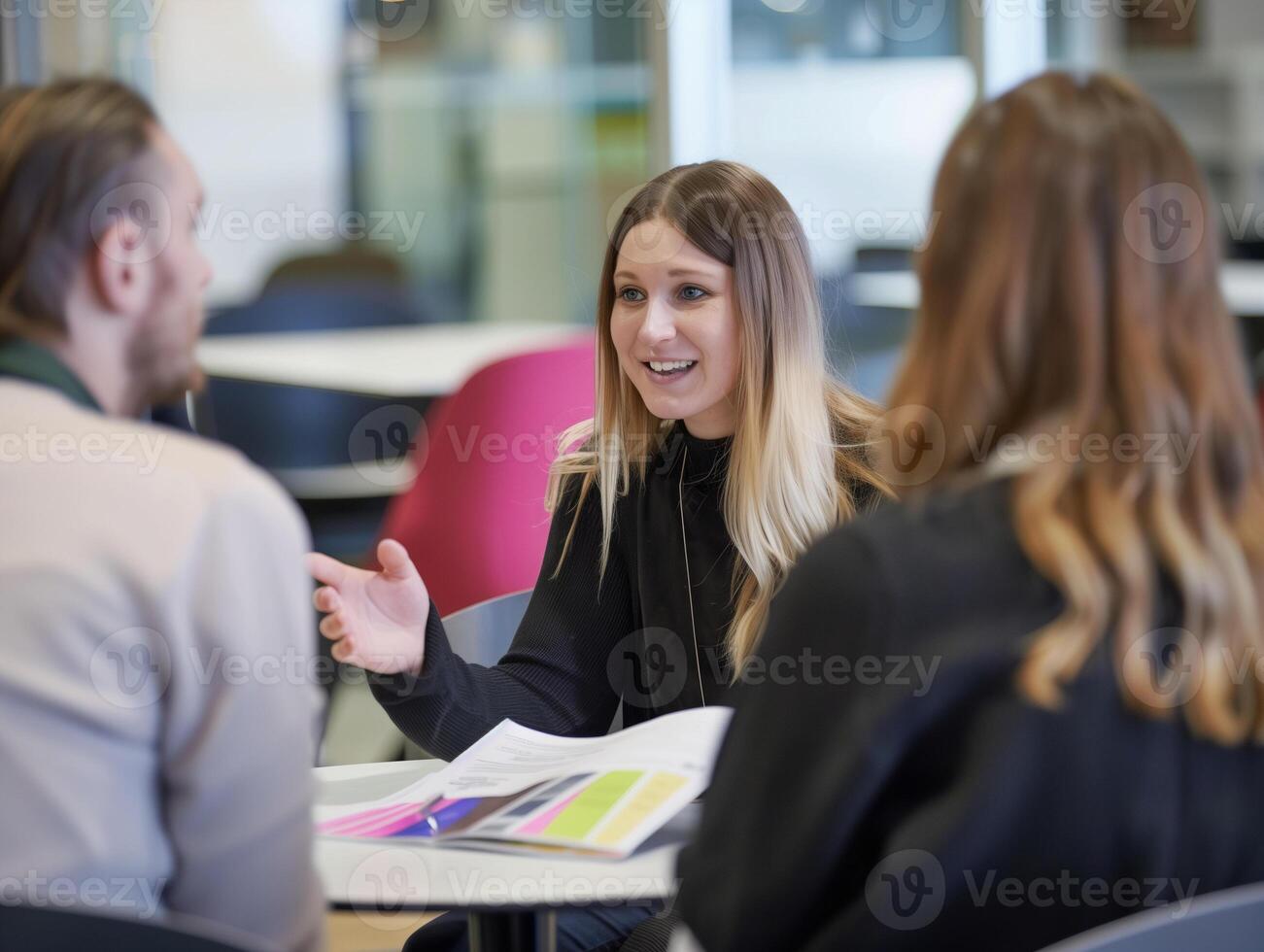 A female consultant is engaging in a conversation with a couple clients photo