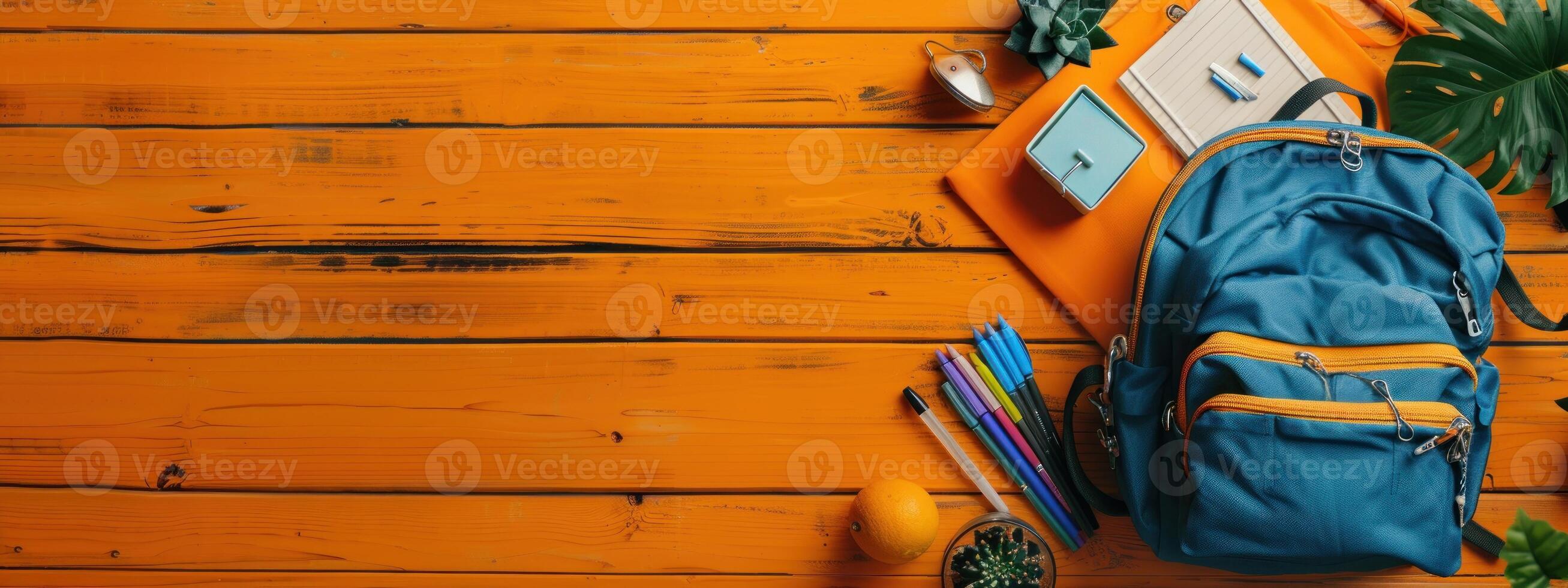 A backpack and a few other items are on a wooden surface photo