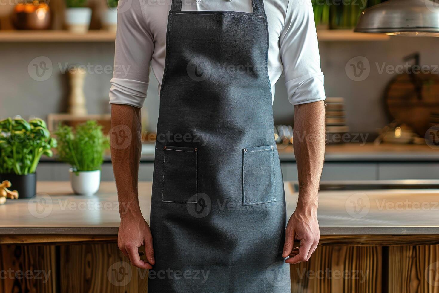 A chef stands in front of a counter with apron on photo