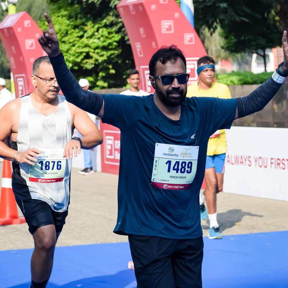 New Delhi, India - June 15 2024 - Vedanta Delhi Half Marathon race after covid in which marathon participants about to cross the finish line, Delhi Half Marathon 2023 photo