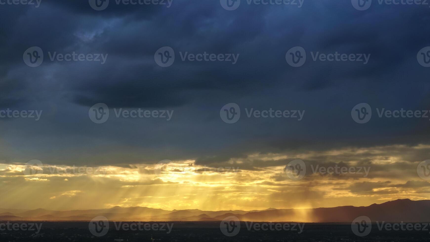 Sunset in the mountains with sun rays and clouds photo