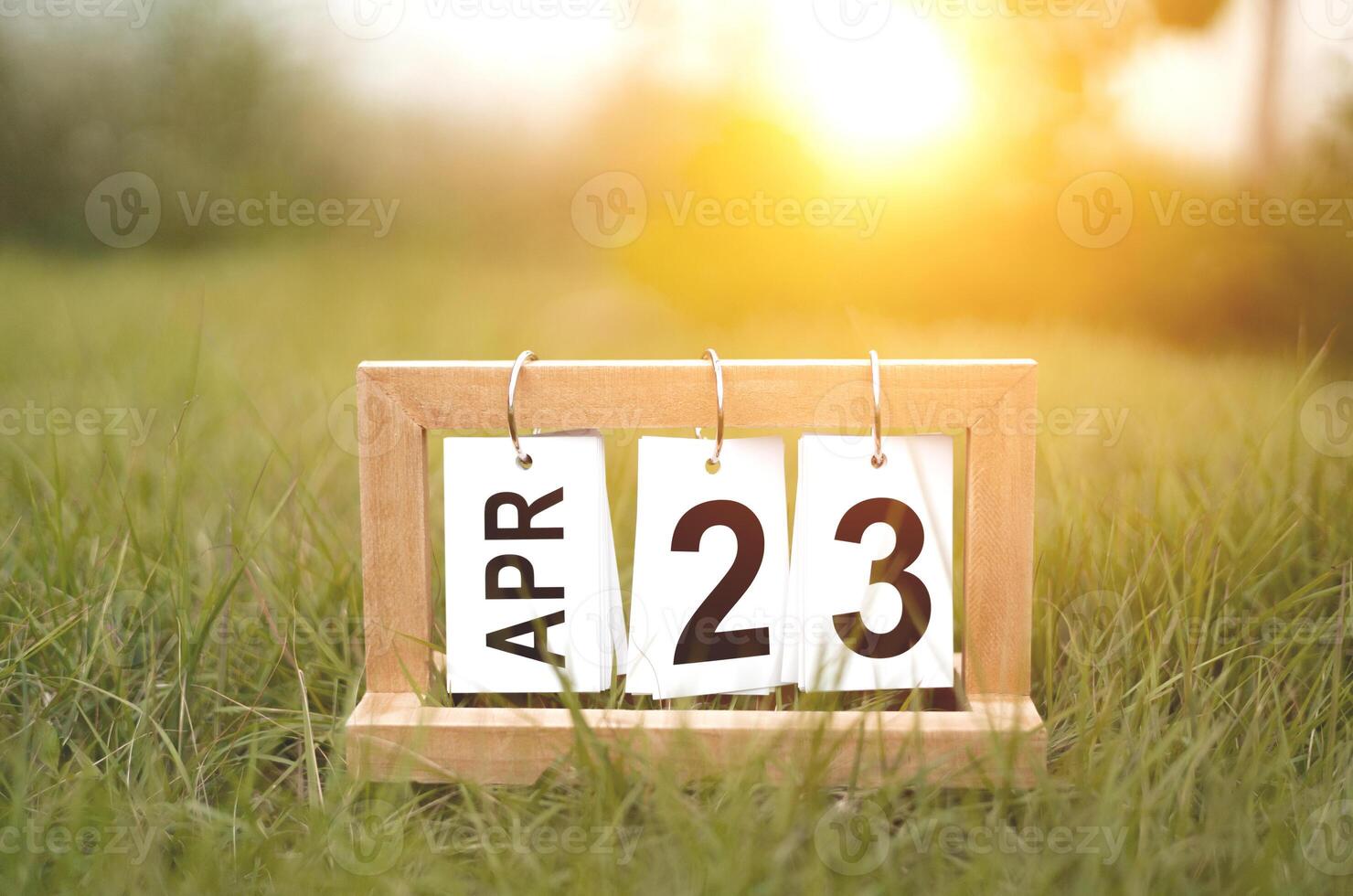 Calendar page showing April 23 on grass with a green background. photo