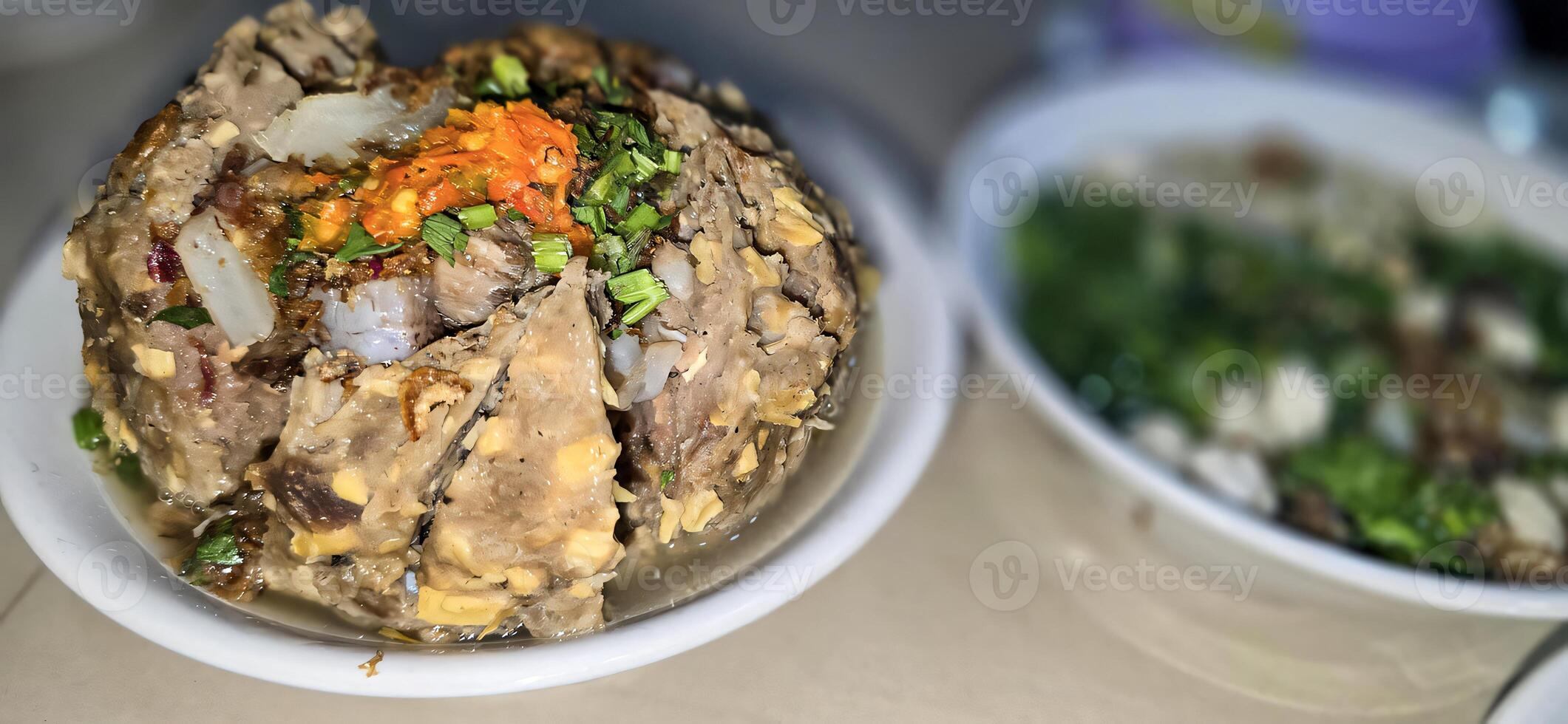 Giant Bakso, or Jumbo meatball is indonesian meatball style served with beef broth soup and noodle springkled with fried onion and spring onion coupled with chili sauce on the top photo