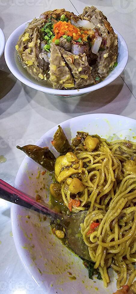 Giant Bakso, or Jumbo meatball is indonesian meatball style served with beef broth soup and noodle springkled with fried onion and spring onion coupled with chili sauce on the top photo