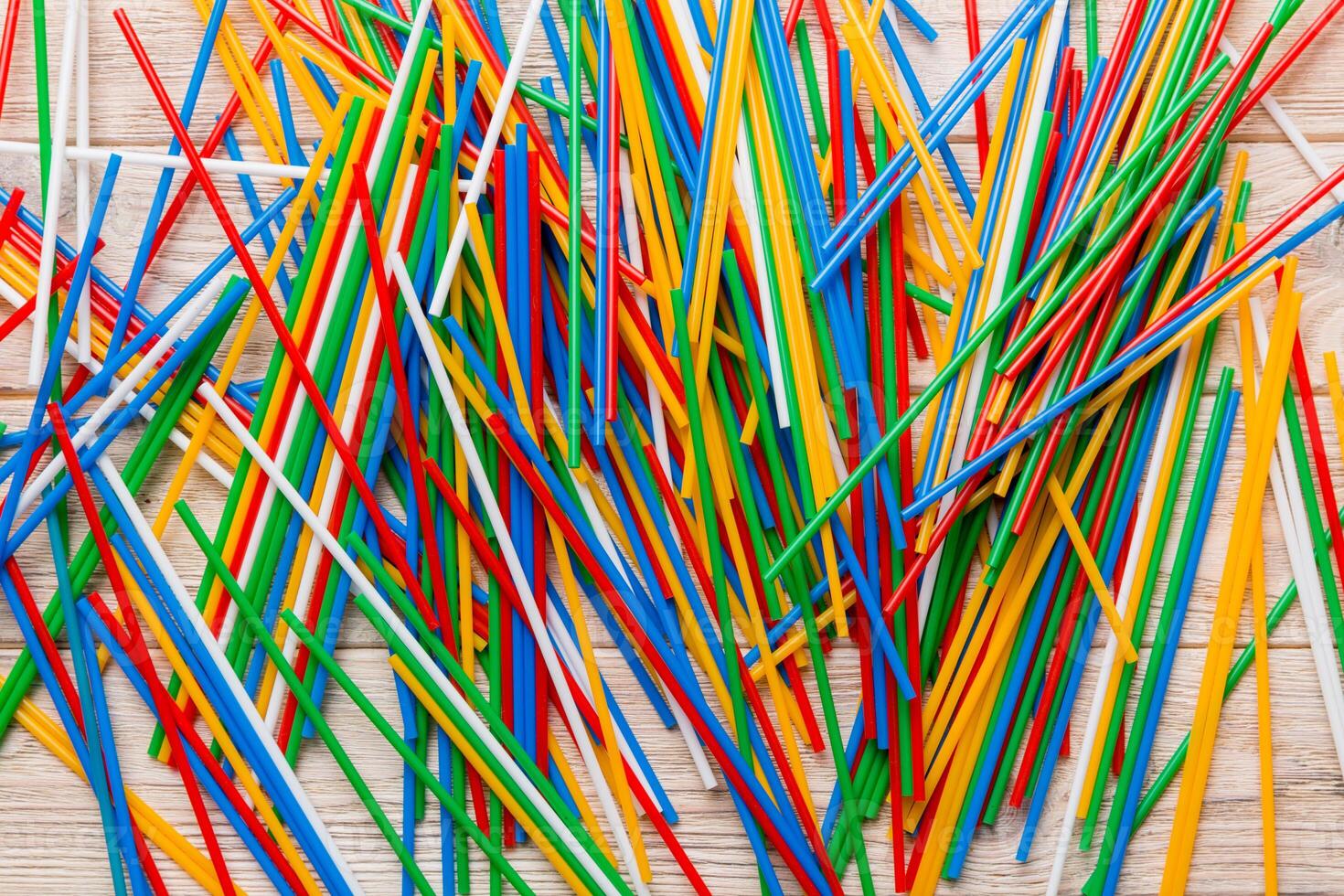 many multi-colored plastic tubes for cocktail on Colored background, top view photo